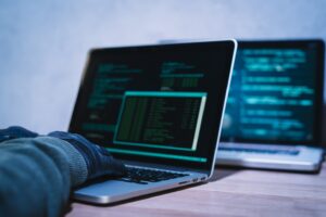 Hacker versucht über einen Laptop ein Netzwerk anzugreifen